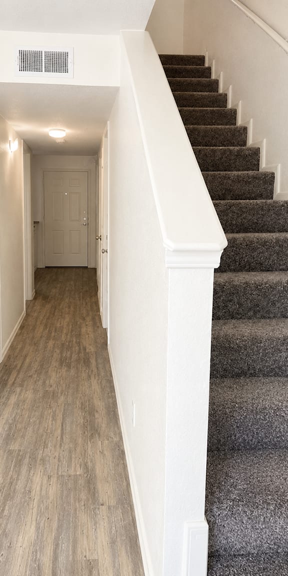 A staircase with a carpeted runner and wooden steps.