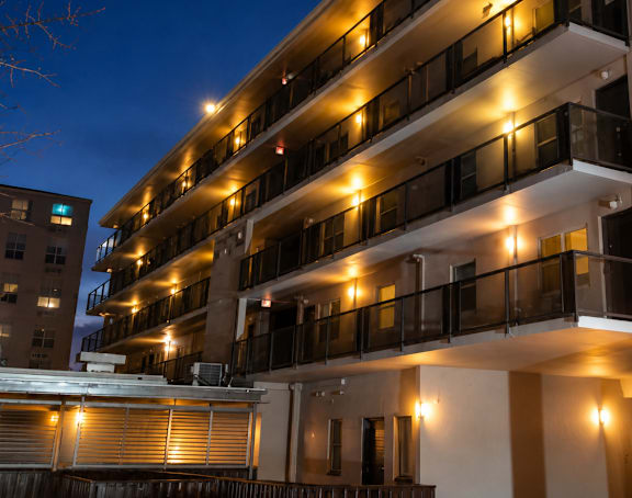 A building with balconies lit up at night.