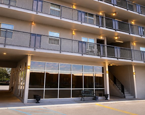 A large building with a lot of windows and lights on the balcony.