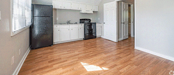 a kitchen with white cabinets and a black refrigerator