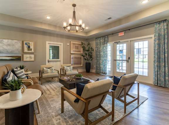 A well-lit living room with a chandelier, sofas, and a coffee table.