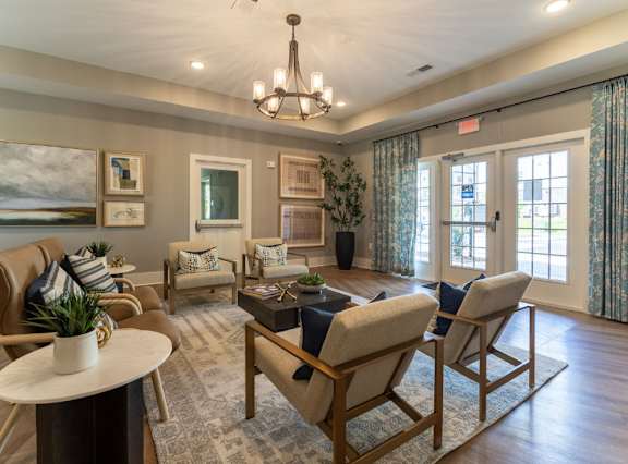 A well-lit living room with a chandelier, sofas, and a coffee table.