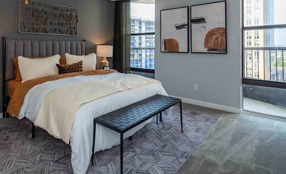 A bedroom with a large bed and a bench in front of it.