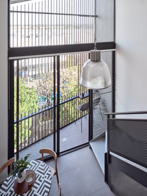 a living room with a balcony and a glass door