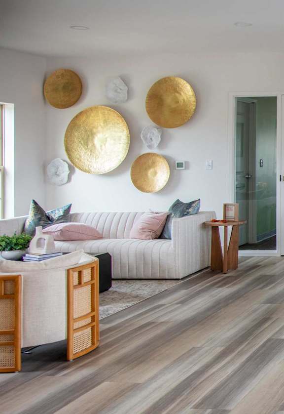 A living room with a white couch and a wooden coffee table.