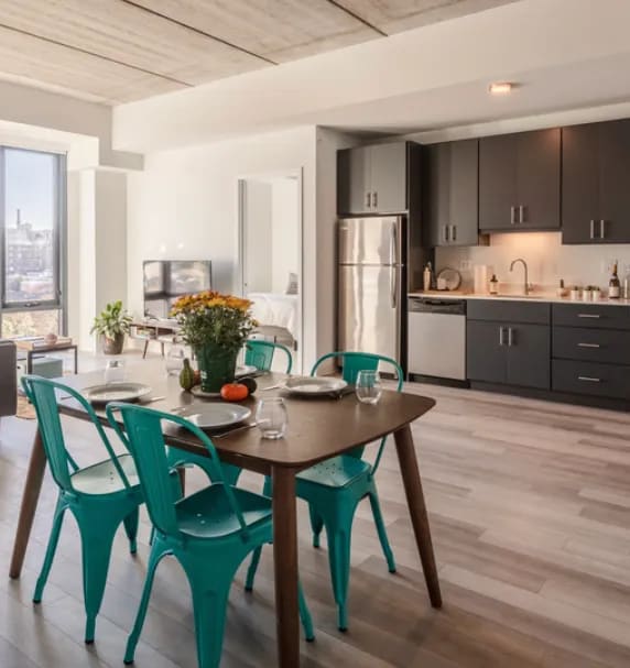 an open kitchen and dining room with green chairs and a table