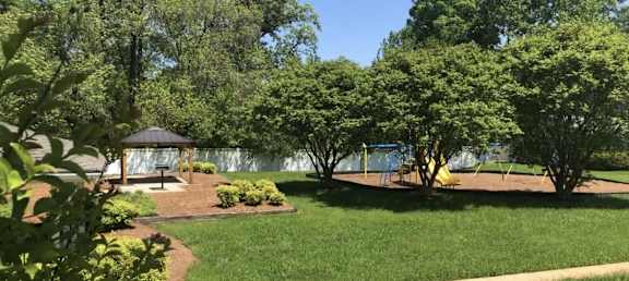 a park with a playground and a lake in the background at Colony Townhomes, Raleigh, NC, 27609