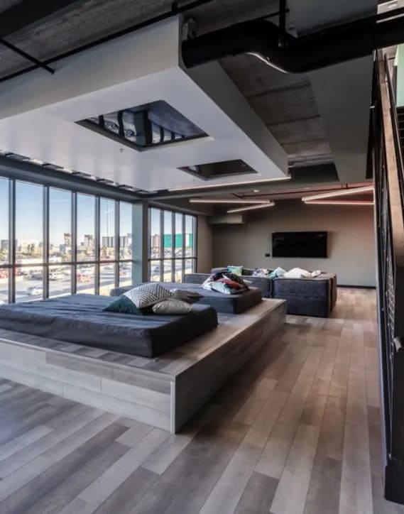 a bedroom with a couch and a bed in a room with floor to ceiling windows