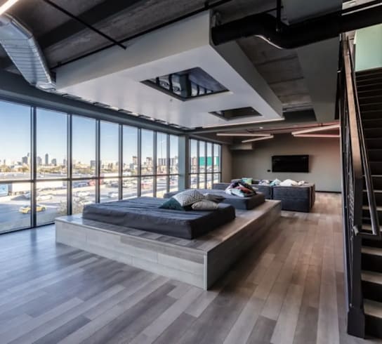 a bedroom with a couch and a bed in a room with floor to ceiling windows