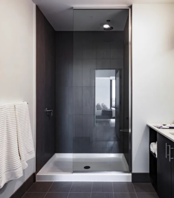 a black and white bathroom with a shower and sink