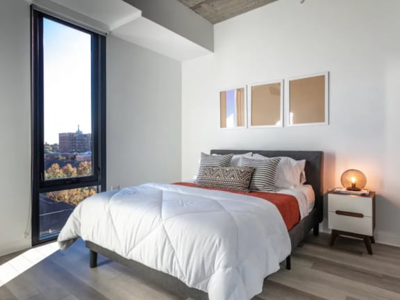 a bedroom with a bed and a large window