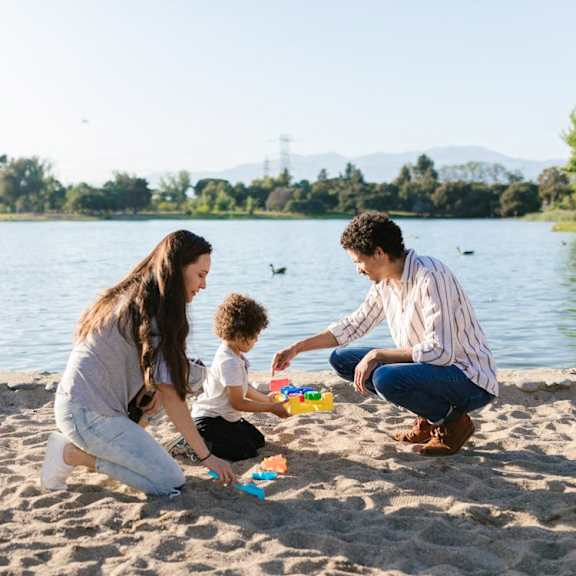 A family playing with toys on the beach.