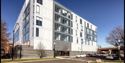 a large white building with cars parked in front of it