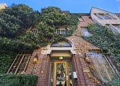 Thumbnail 6 of 6 - the front of a brick building with a door and ivy on it