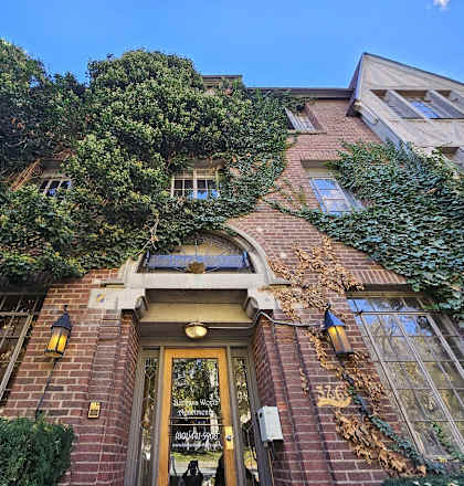 A building with a door and windows covered in greenery.