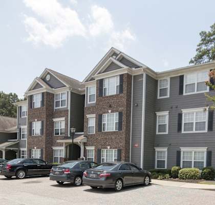 an apartment building with cars parked in front of it