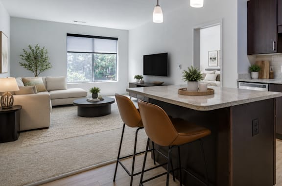 A modern kitchen with a large island and chairs.