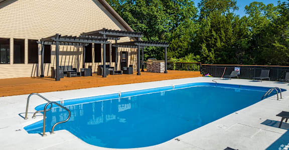 a swimming pool with a pergola next to a house