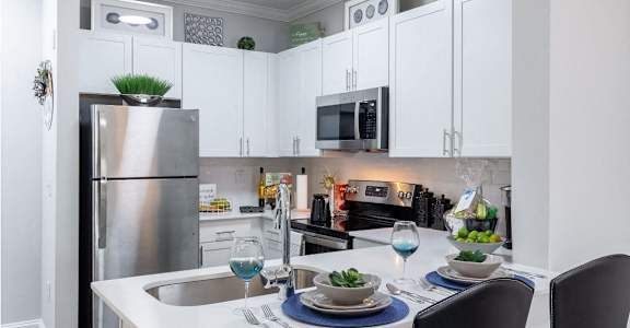 a kitchen with white cabinets and stainless steel appliances