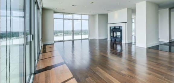 unfurnished living room with floor to ceiling windows, wood plank flooring and fire place