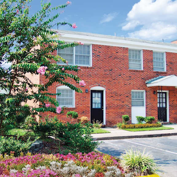 A red brick building with a white door and windows.