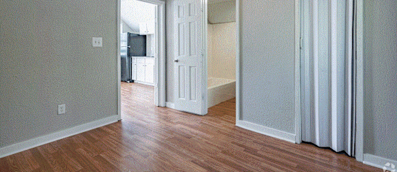 an empty living room with a ceiling fan