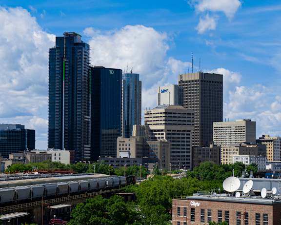 A cityscape with a train on the tracks and a building with the word "Citytv" on it.