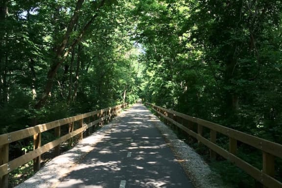 a bridge over a river with trees on both sides  at The Landing Apartments, Indianapolis, Indiana