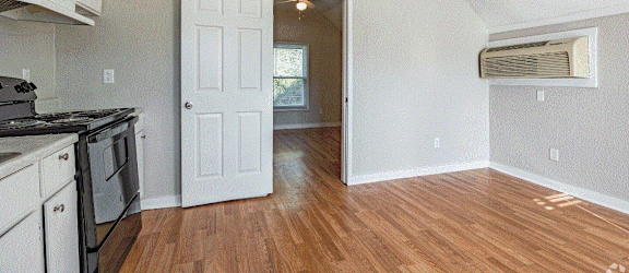 an empty kitchen and living room with an open door
