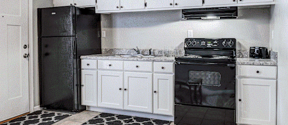 a kitchen with white cabinets and black appliances