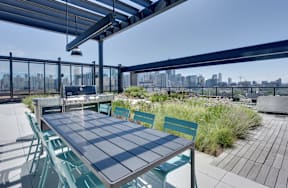 A table with chairs is set up on a rooftop patio.