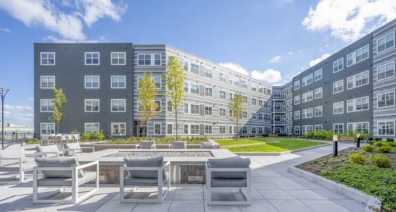 a courtyard with a fire pit and a large building in the background