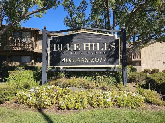 a sign studio homes in front of trees and flowers