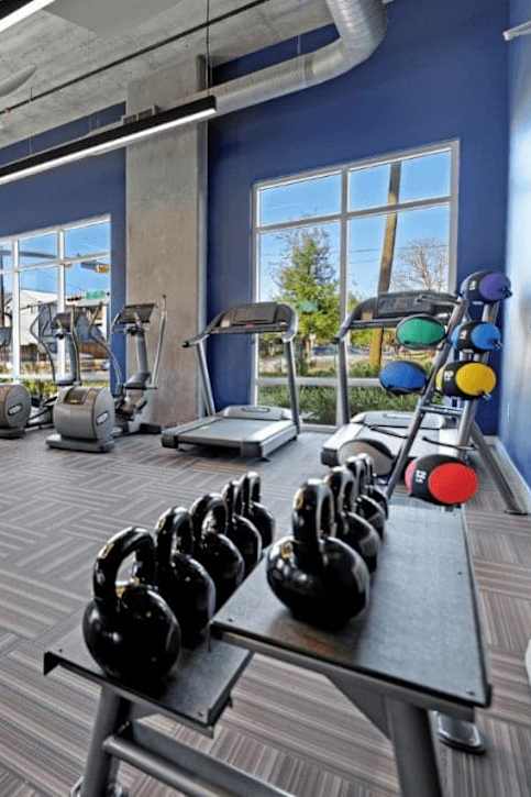 A gym with a variety of equipment including weights and machines.