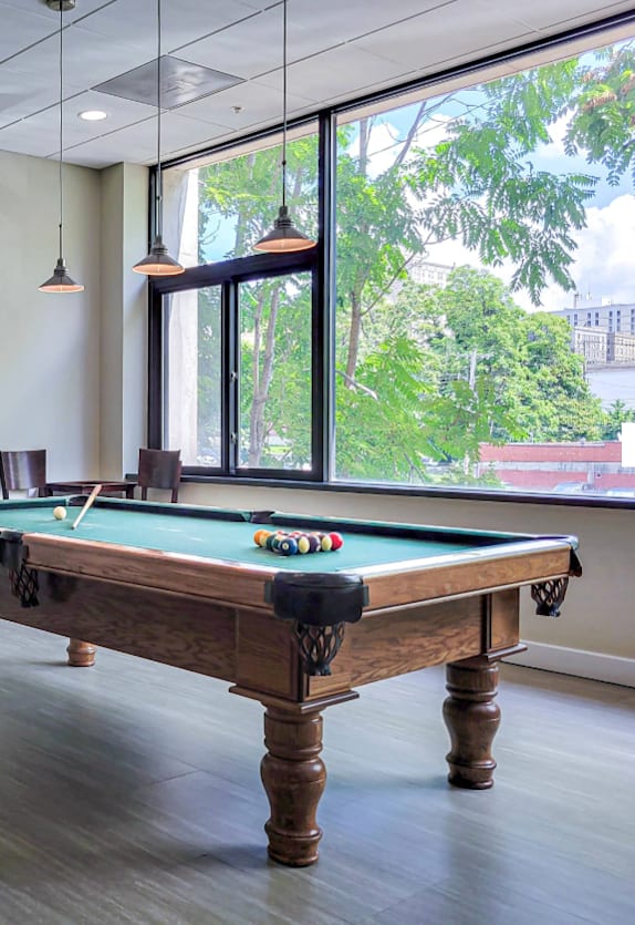 a game room with a pool table and a window