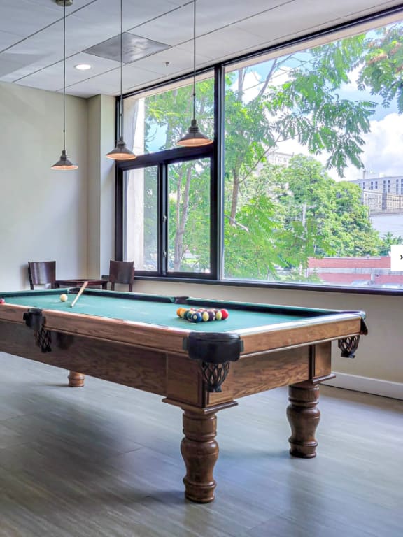 a game room with a pool table and a window