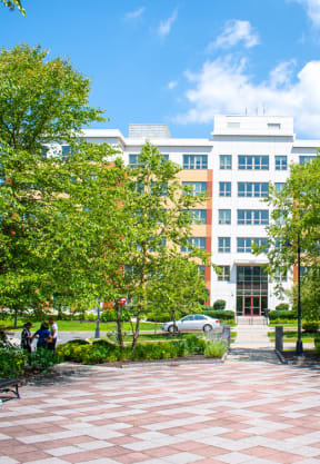 a large white building with a red brick walkway in front of it