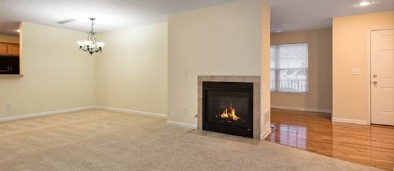 A living room with a fireplace and a chandelier.