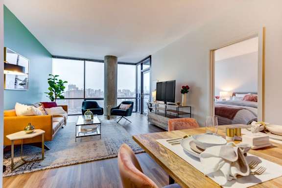 A modern living room with a dining table set for two.