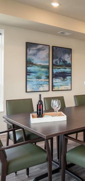 a dining room table with a bottle of wine and glasses