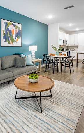 A living room with a grey couch and a wooden coffee table.