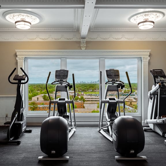 an exercise room with treadmills and a window with a view