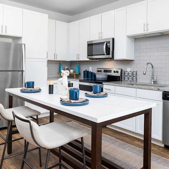 a kitchen and living room with a table and chairs