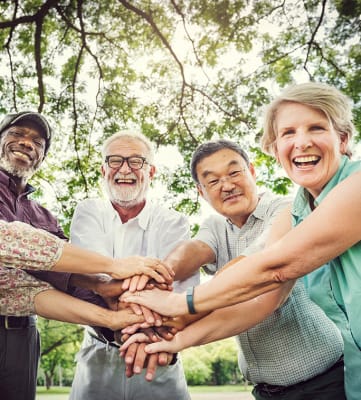 a group of people standing in a circle with their hands together