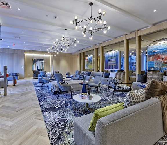 a lobby with couches and chairs and chandeliers