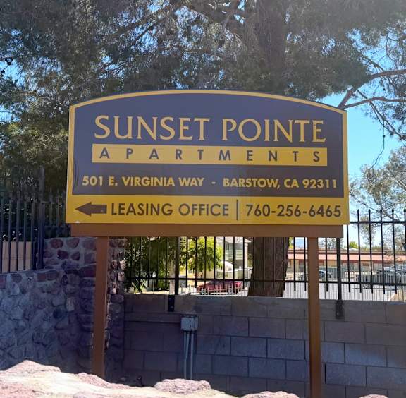 A sign for Sunset Pointe Apartments with a leasing office phone number.