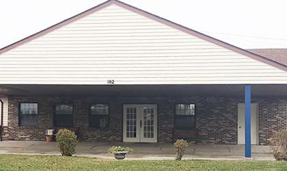 a building with a brown roof and blue pillars