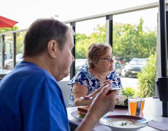 a man and a woman sitting at a table eating food