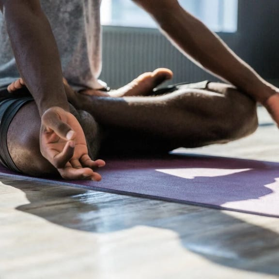 a person doing yoga on a purple mat on the floor
