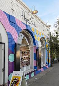 The exterior of a store named Happy Store with a colorful design.